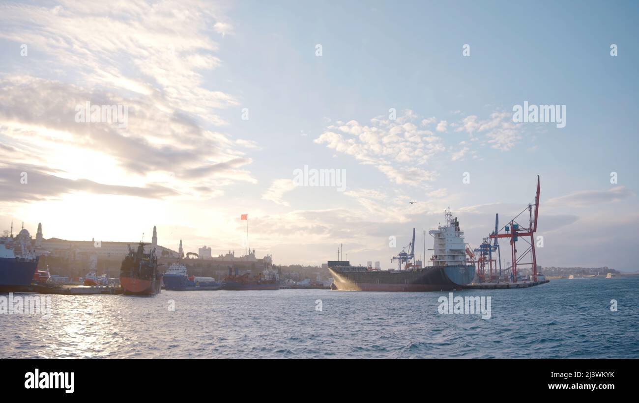 Big cargo ships are beautiful. Action. Seascape in which large water transports float against the background of the sea and the bright sun above. Stock Photo