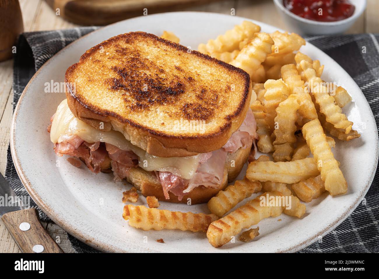 Grilled ham and cheese sandwich and french fries on a plate Stock Photo