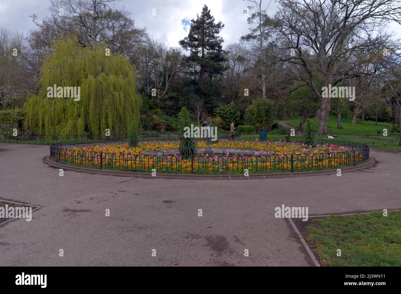 View into Thompson's Park,Cardiff from the main entrance gate on Romilly Road with the bronze statue Joyance in the  centre of flower bed. Stock Photo