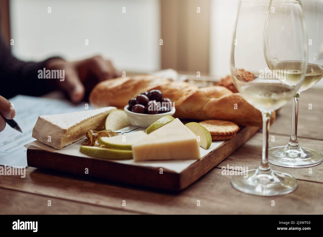 Something to go with your wine. Shot of a man enjoying a cheese platter and tasting different wines. Stock Photo