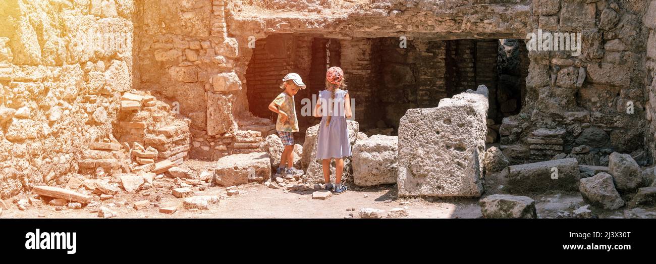 kids sibling girl and boy travelers travel and explore the ancient excavations of the ruins of the ancient Lycian city of Phaselis in Turkey in summer Stock Photo