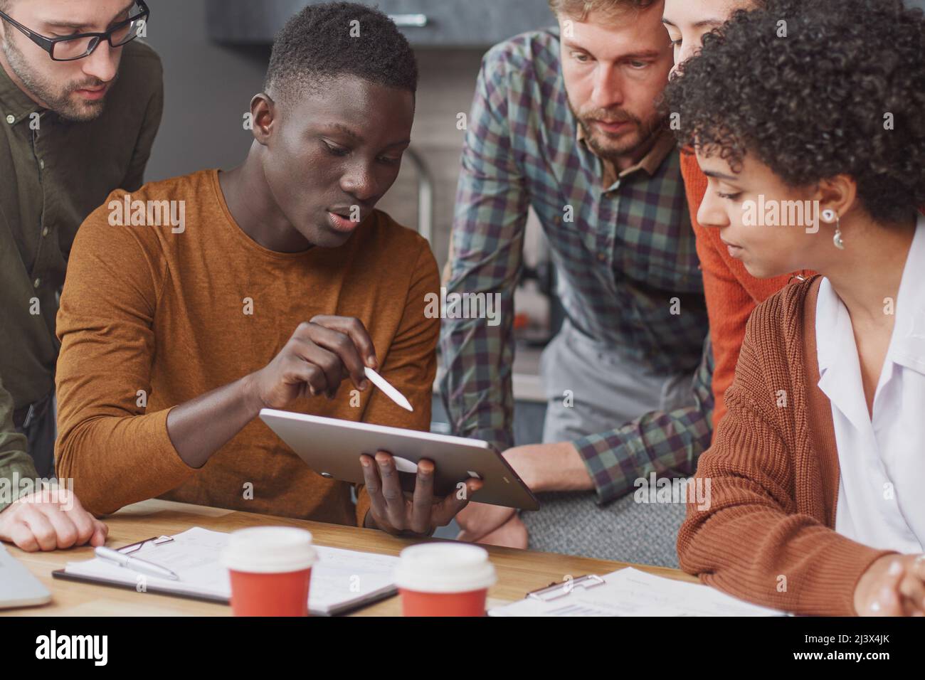 colleagues using a digital tablet during a work meeting . Stock Photo