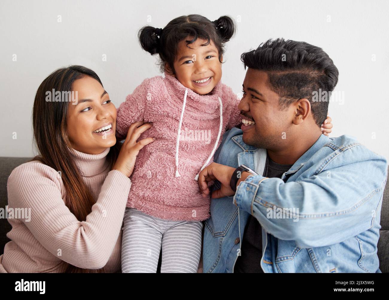 Her giggle is my favourite sound. Shot of parent playfully tickling their daughter. Stock Photo