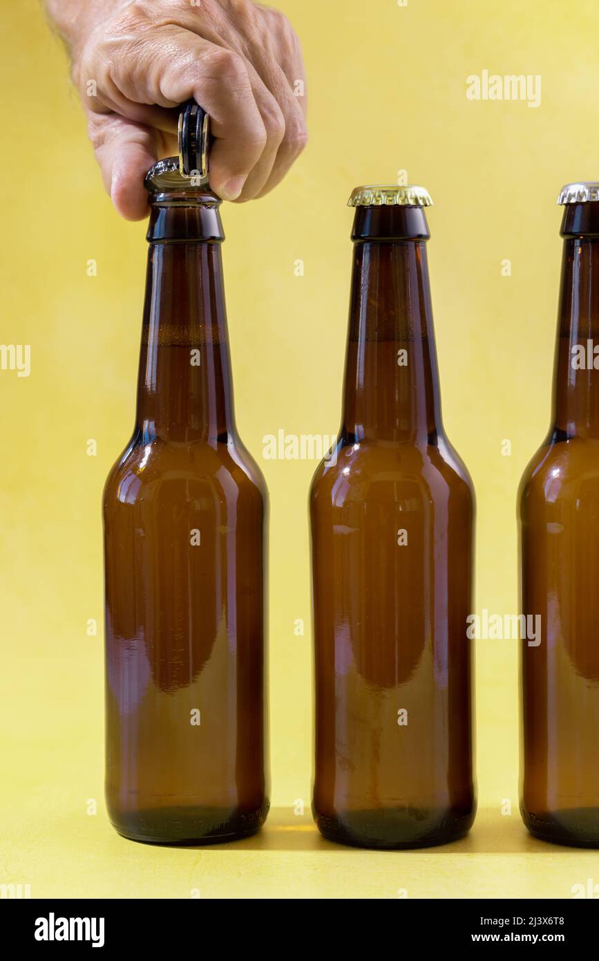 Hand opening beer bottle with blurred background Stock Photo
