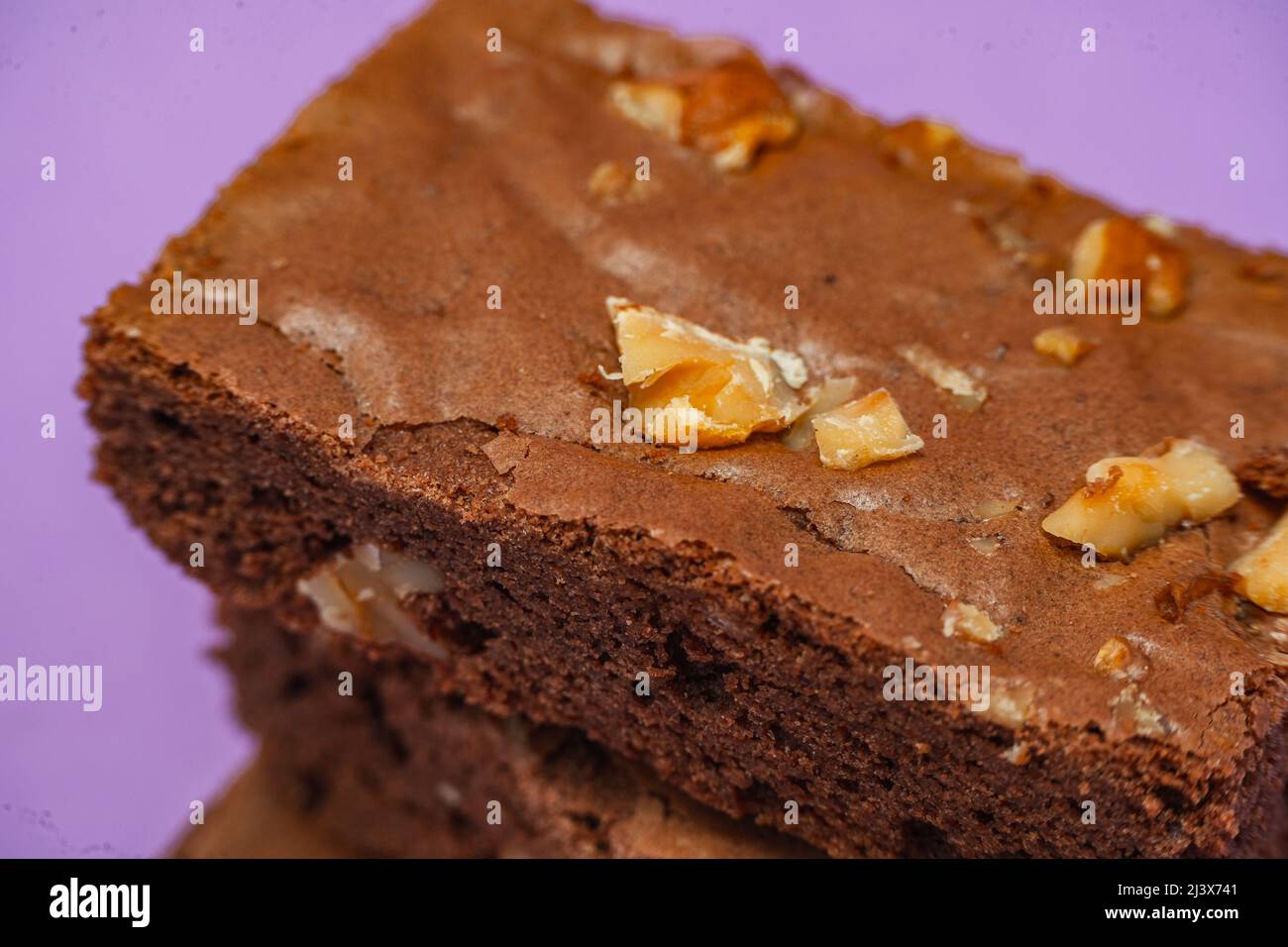Homemade chocolate brownie squares with pecan pieces. Orange Background. Natural, healthy food concept. High view. Stock Photo