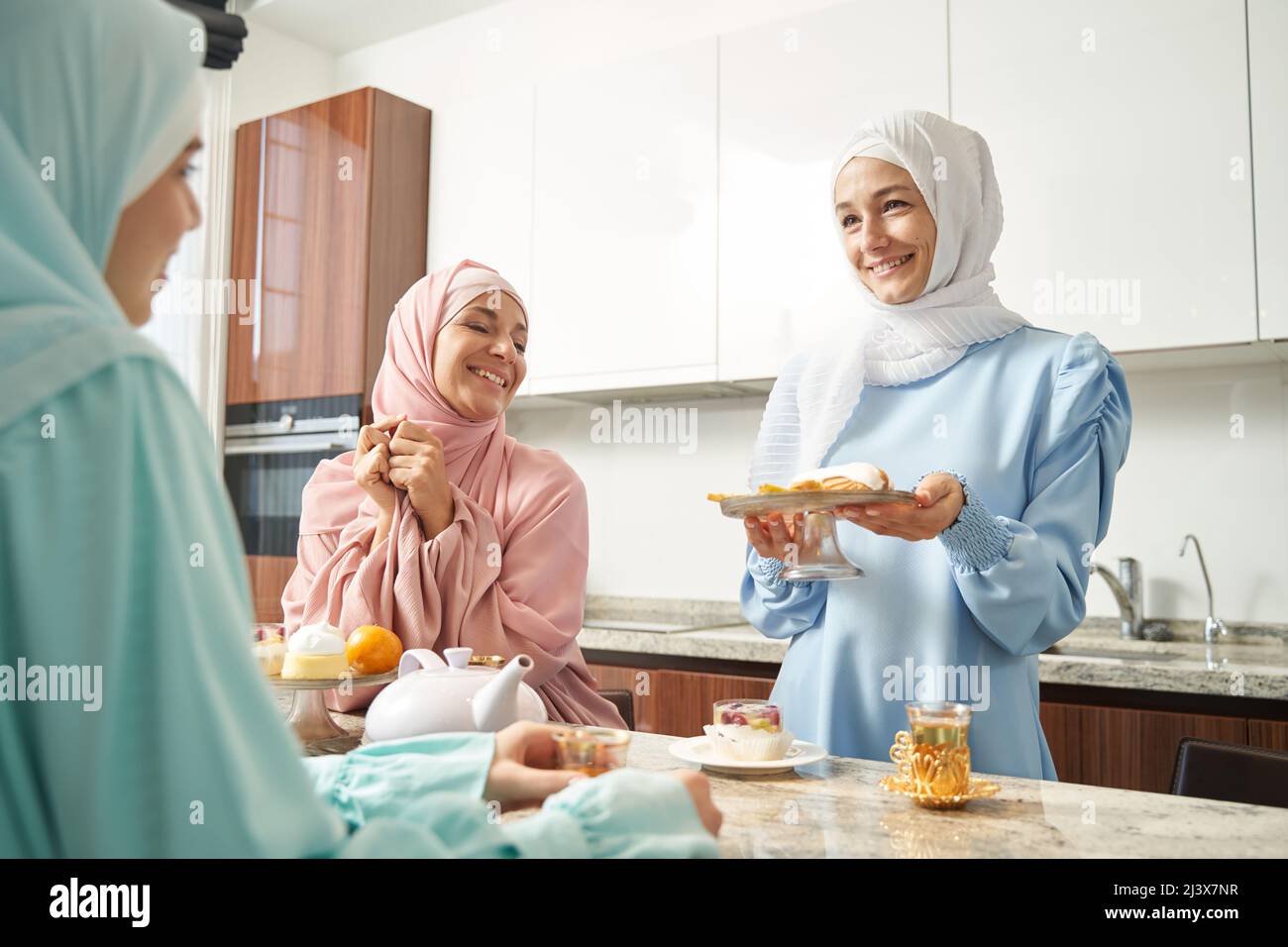 Cheerful woman welcoming guests hi-res stock photography and images - Alamy