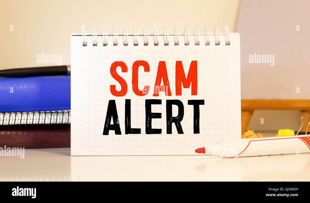White blank notepad on office wooden table Scam Alert concept Stock ...