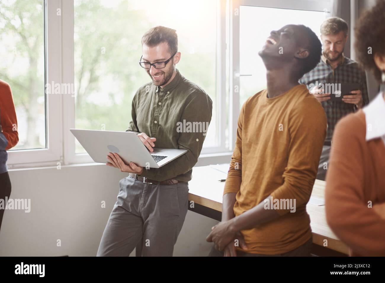 cheerful young employees standing near a table in a coworking ce Stock Photo