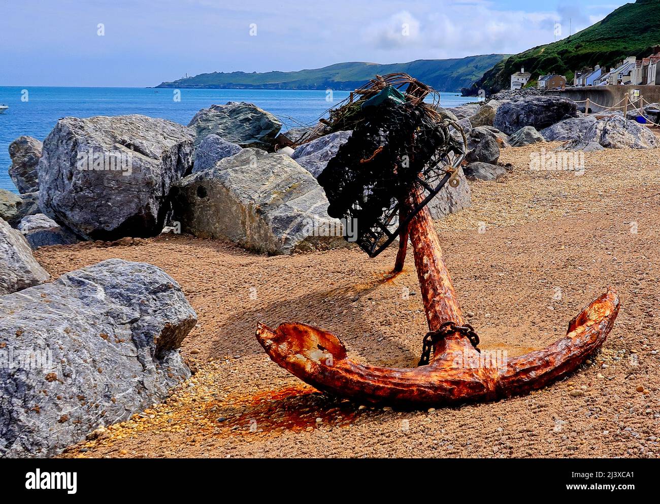 An old rusty anchor on the pebbled beach at Beesands Stock Photo