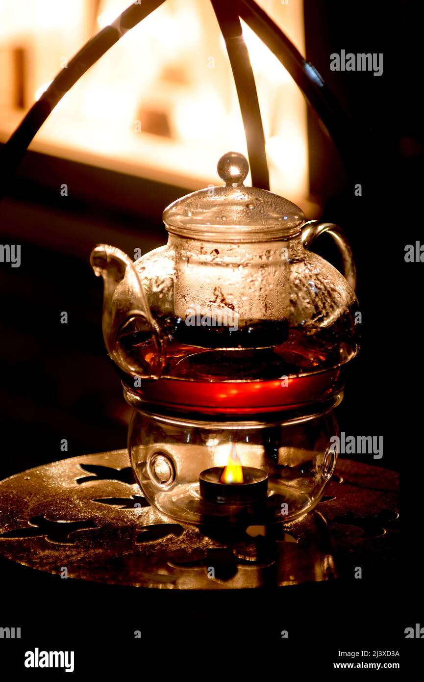 Glass teapot for tea making. Heating from a candle Stock Photo Alamy