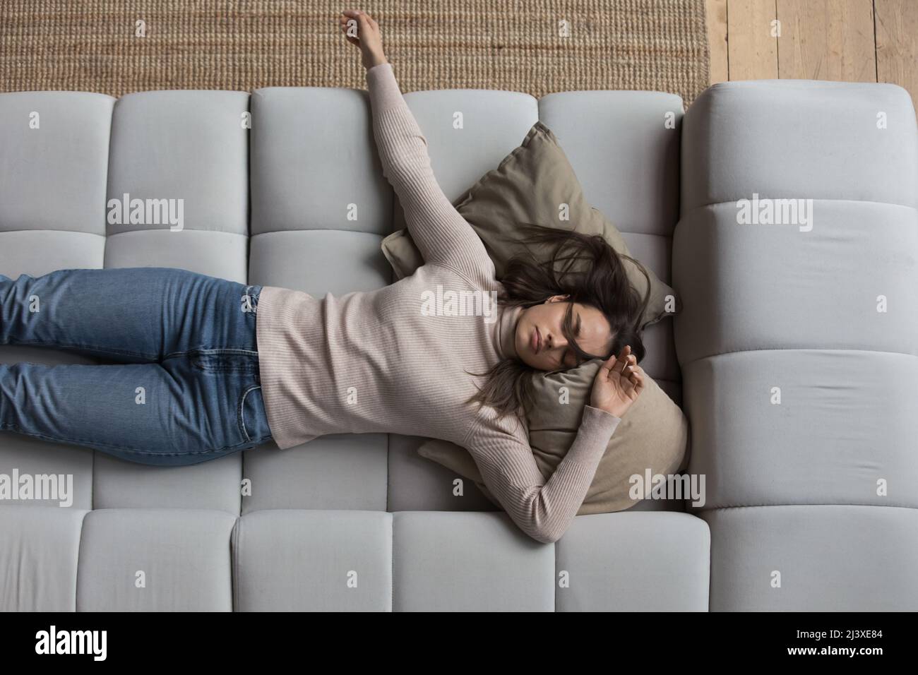 Sleepy girl in casual clothes resting on couch at home Stock Photo