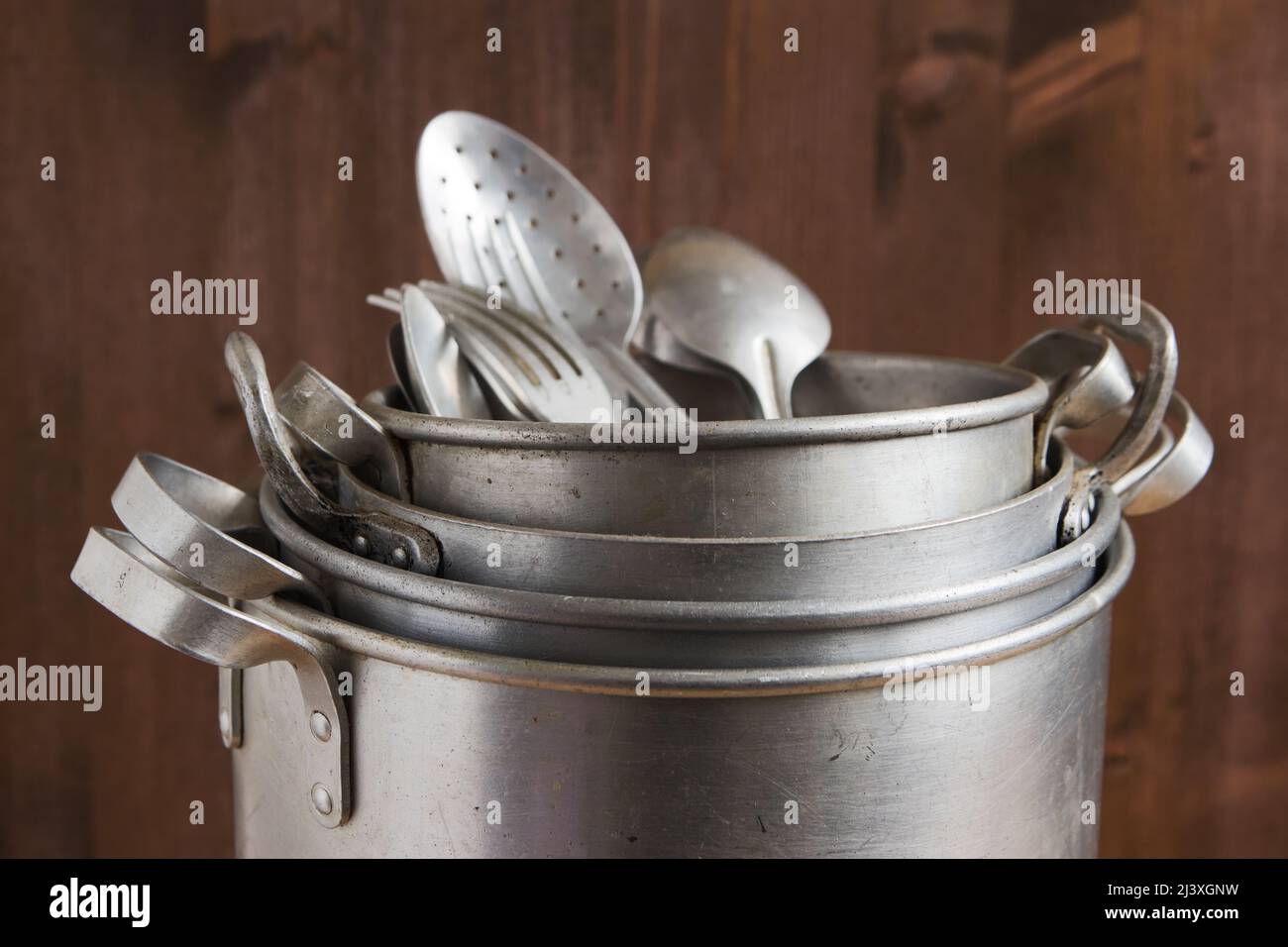 Vintage aluminum kitchen utensils, pan, metal cooking pots, spoons, forks Stock Photo