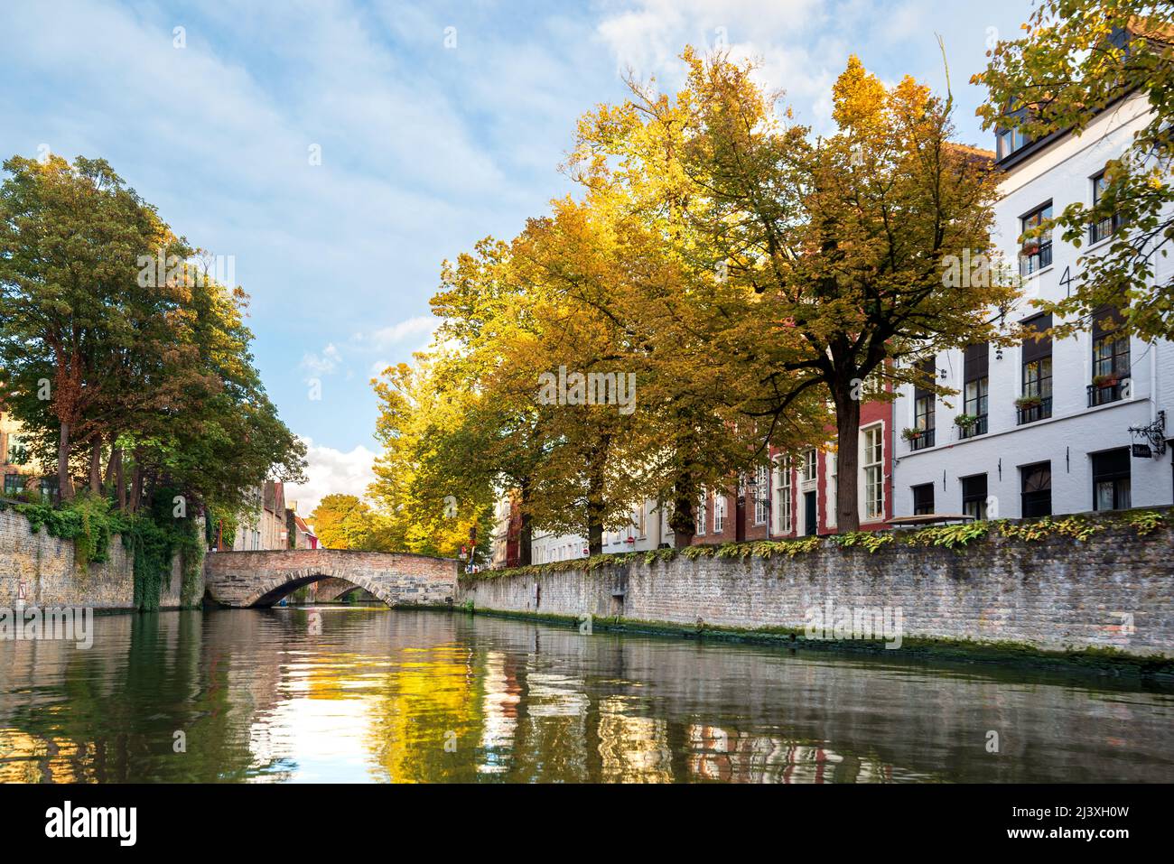 Autumn view of the historical canal in Bruges, Belgium with a beautiful reflection of autumn yellow trees in the water. Stock Photo