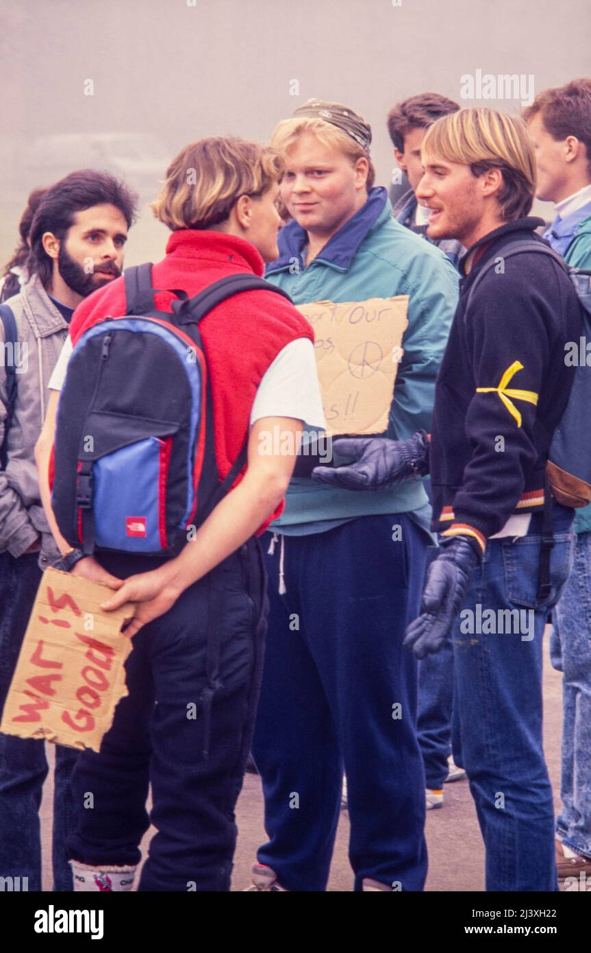 Student  with a plackard reading 'war is good' engaged in a debate with a group of students at an anti-war protest at Oregon State University in response to the US launch of Operation Desert Storm in January 1991 Stock Photo