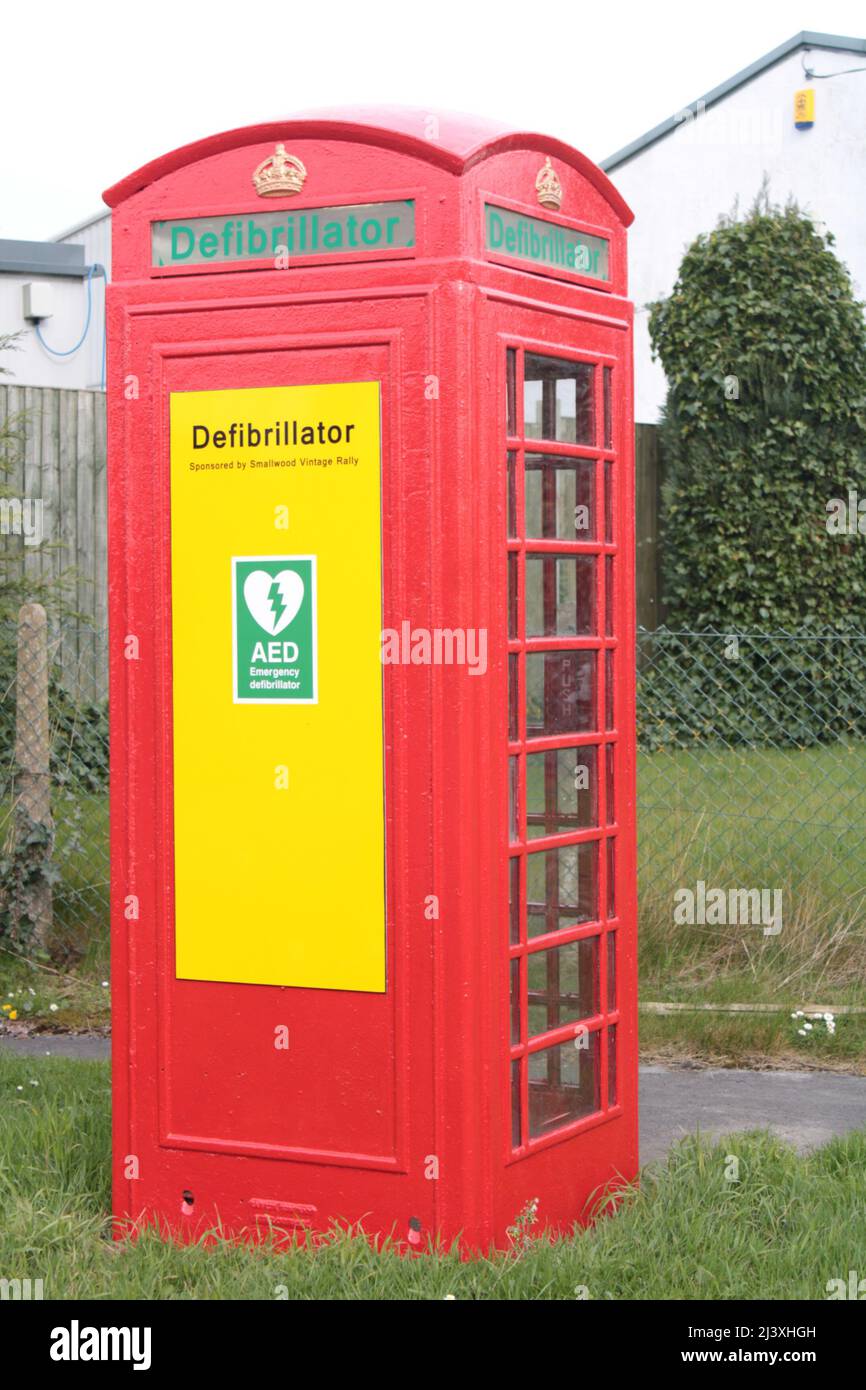 Defibrillator in a red phone box.  repurposed phone box concept. Smallwood, Cheshire, UK Stock Photo