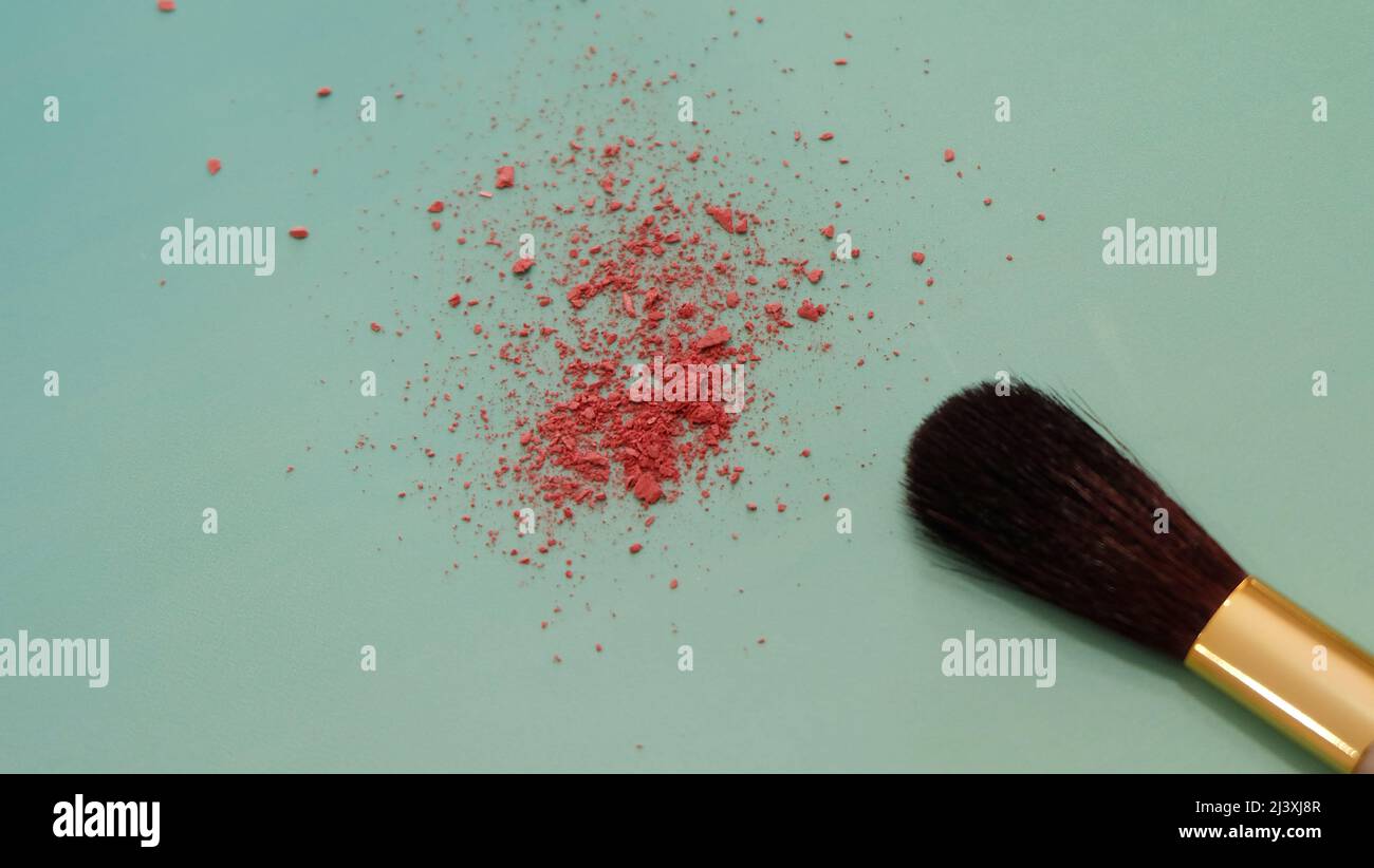 Closeup photo of the tip of makeup brush, with bits of red cosmetic blush powder near the brush tip. Stock Photo