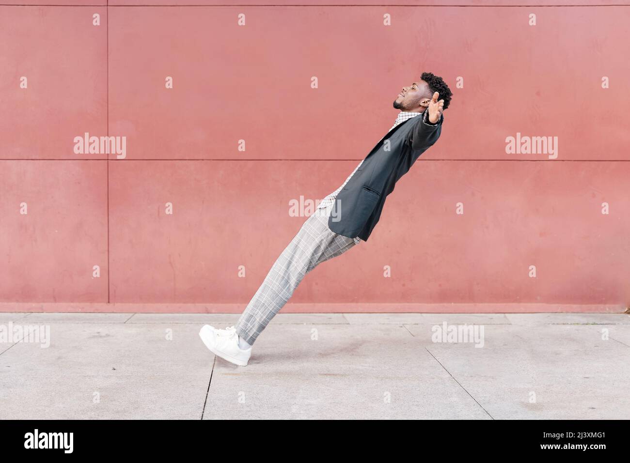 african-american man falling backwards onto concrete floor Stock Photo