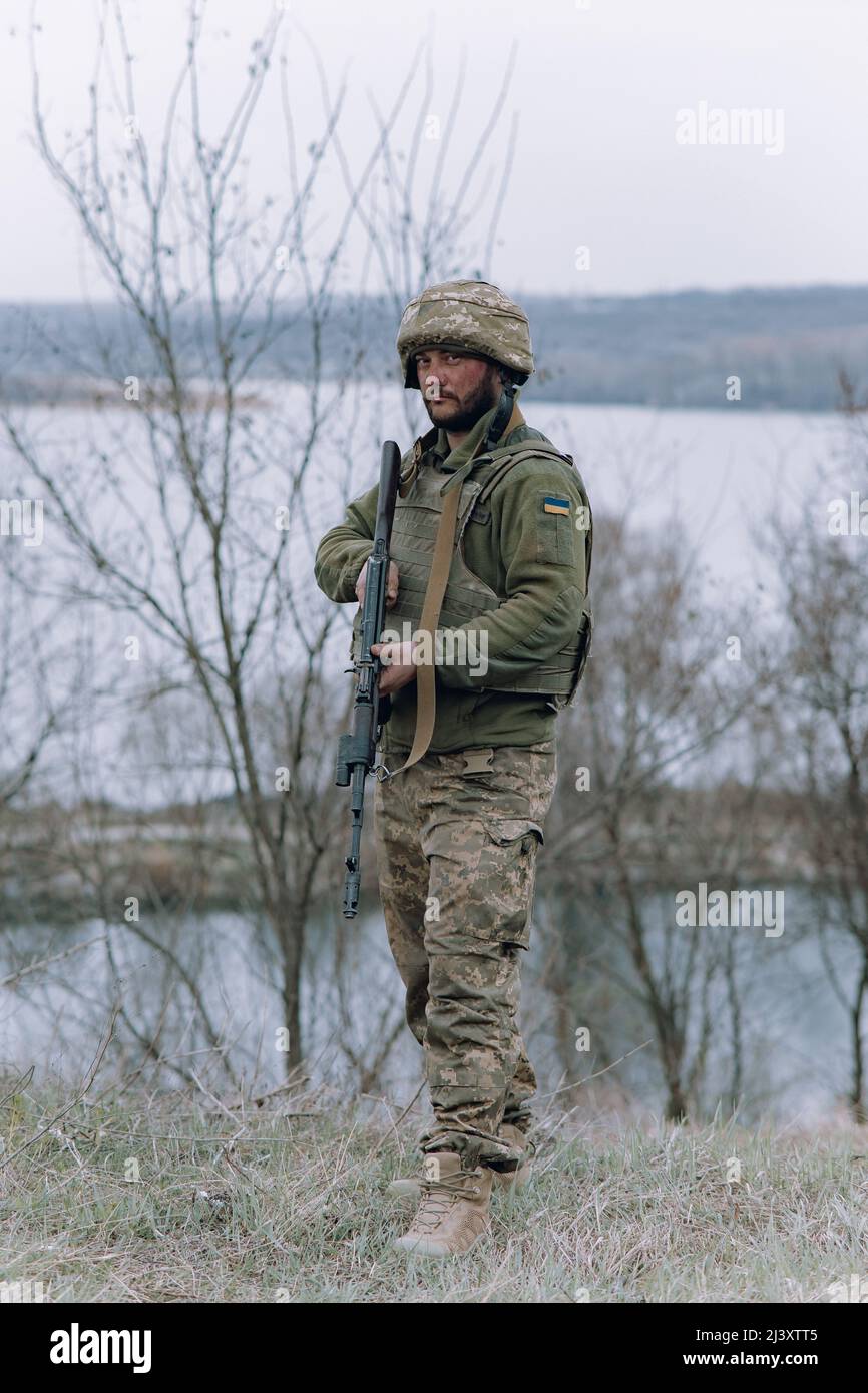 Ukrainian soldier stands with kalashnikov assault rifle in his hands ...