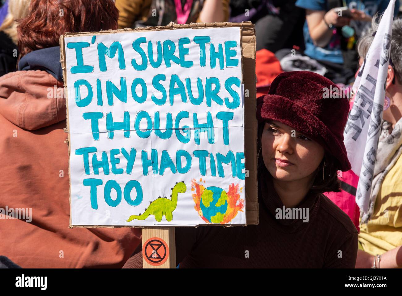 Extinction Rebellion protesters launching a period of civil disruption in London from the 9 April 2022. Female with placard. Dinosaurs extinction Stock Photo