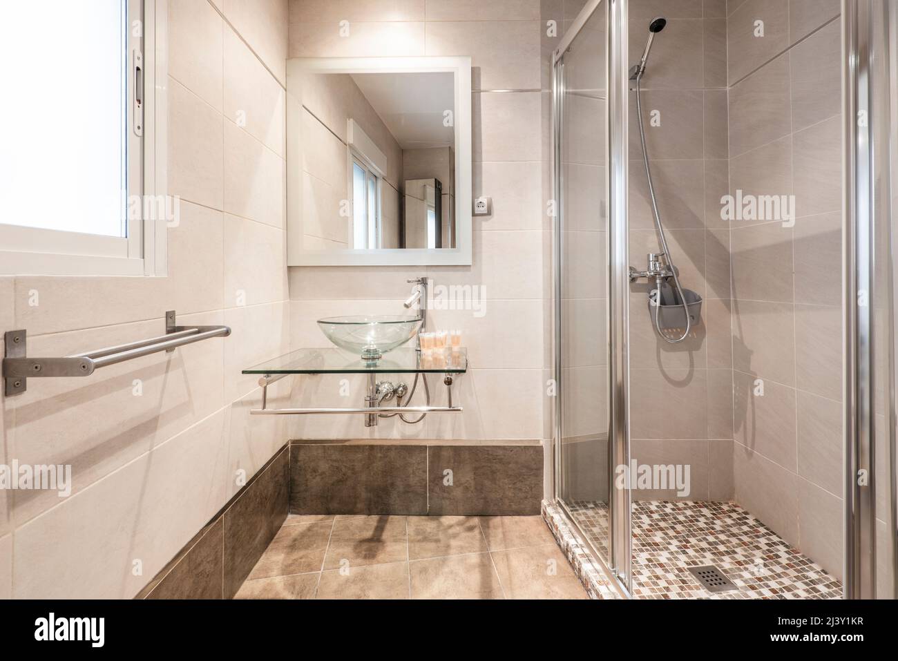 Bathroom with mirror with gray metal structure, glass washbasin on chrome supports, shower cabin ...