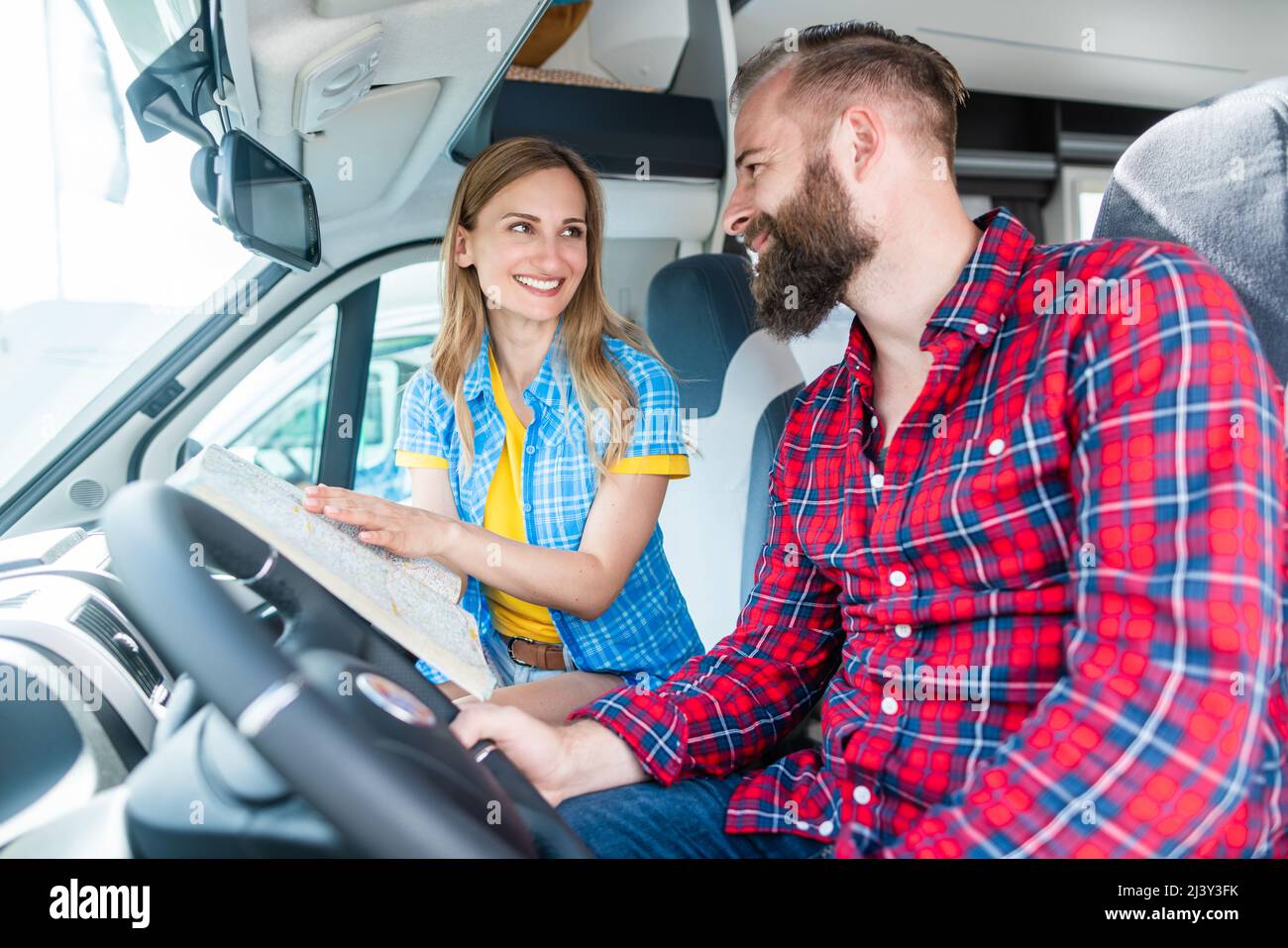 Couple at yard of RV dealer planning the trip with their camper Stock Photo