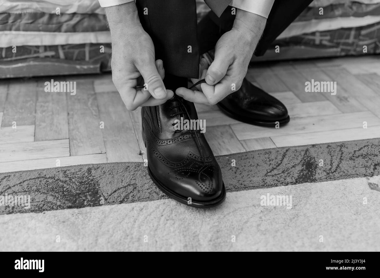 Man tying shoelaces on leather shoes Stock Photo