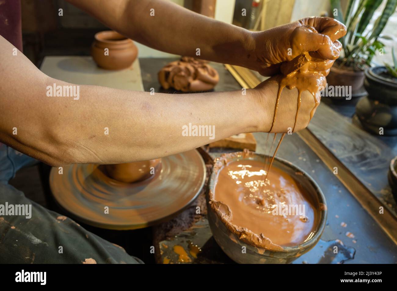 Closeup of potter makes pottery dishes on potter's wheel. Master and
