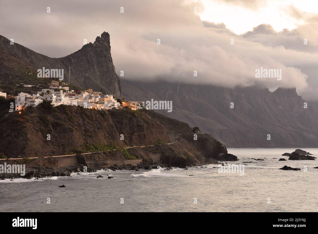 Clifftop village of Almaciga in the northeast of Tenerife Canary Islands Spain. Clouds forming over Anaga Mountains in the evening. Stock Photo