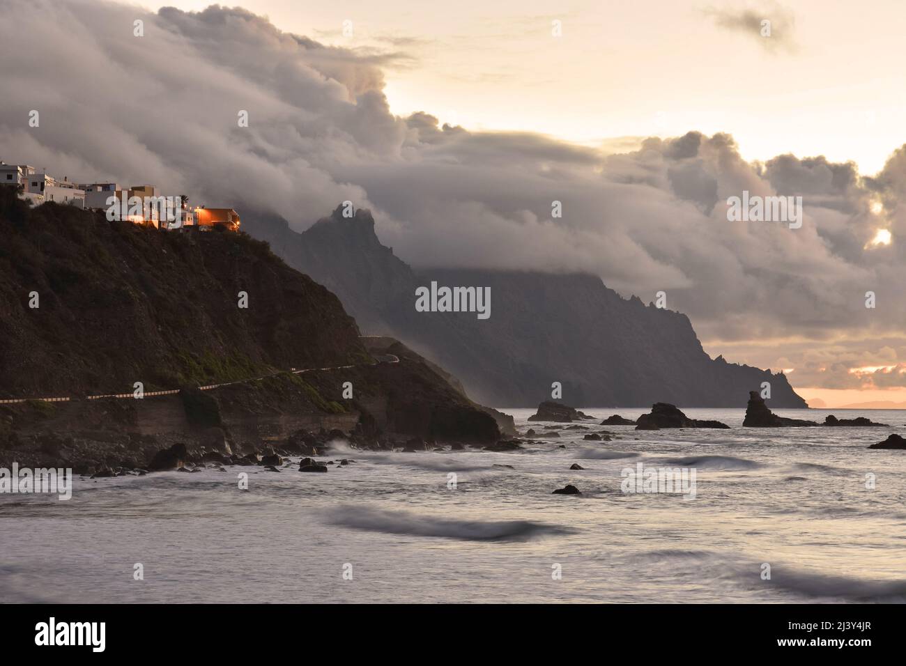 Clifftop village of Almaciga in the northeast of Tenerife Canary Islands Spain. Clouds forming over Anaga Mountains in the evening. Stock Photo