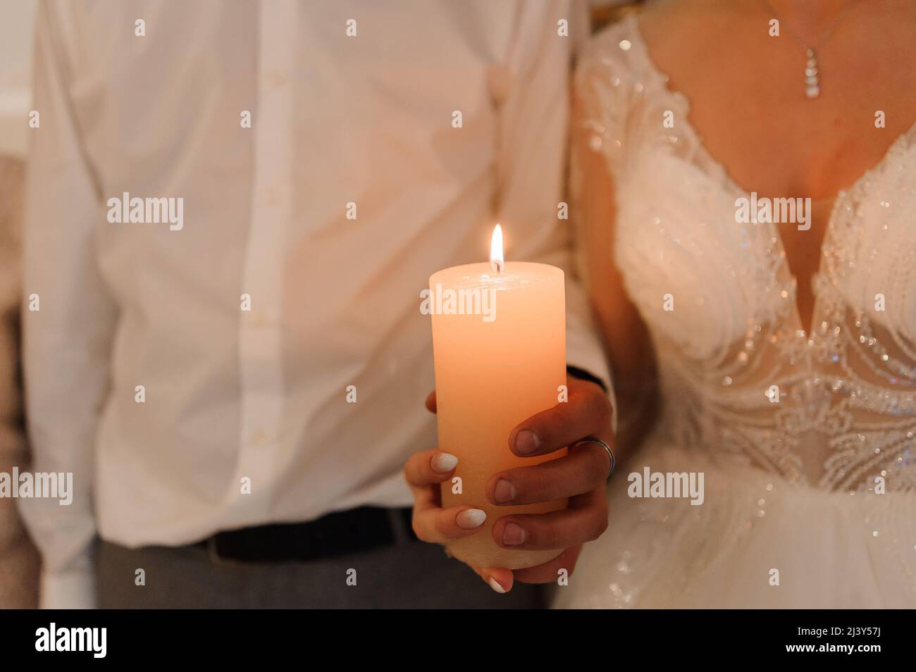Candle in the hands of the newlyweds Stock Photo Alamy