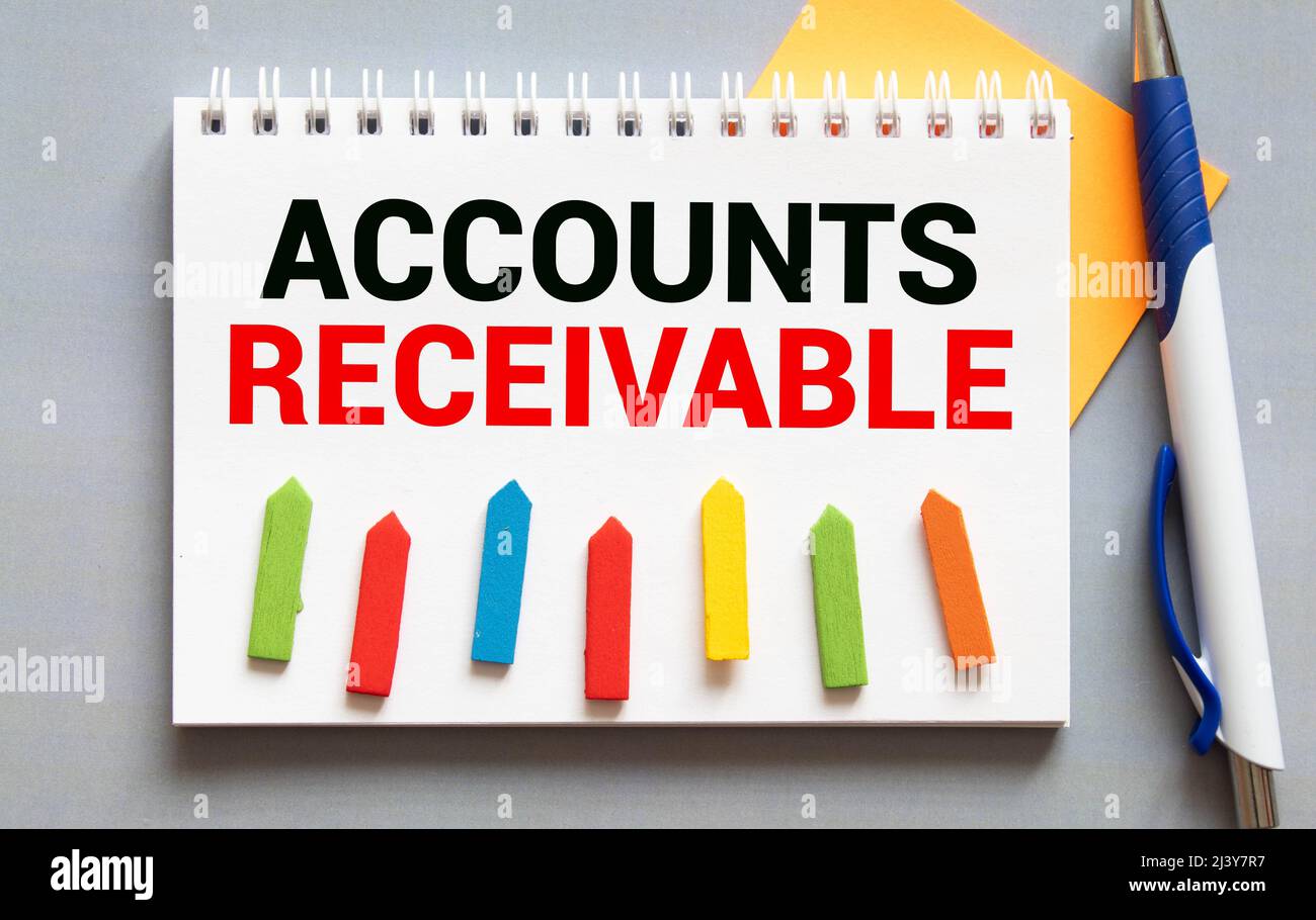 Open book with figures and paper with words accounts receivable Stock