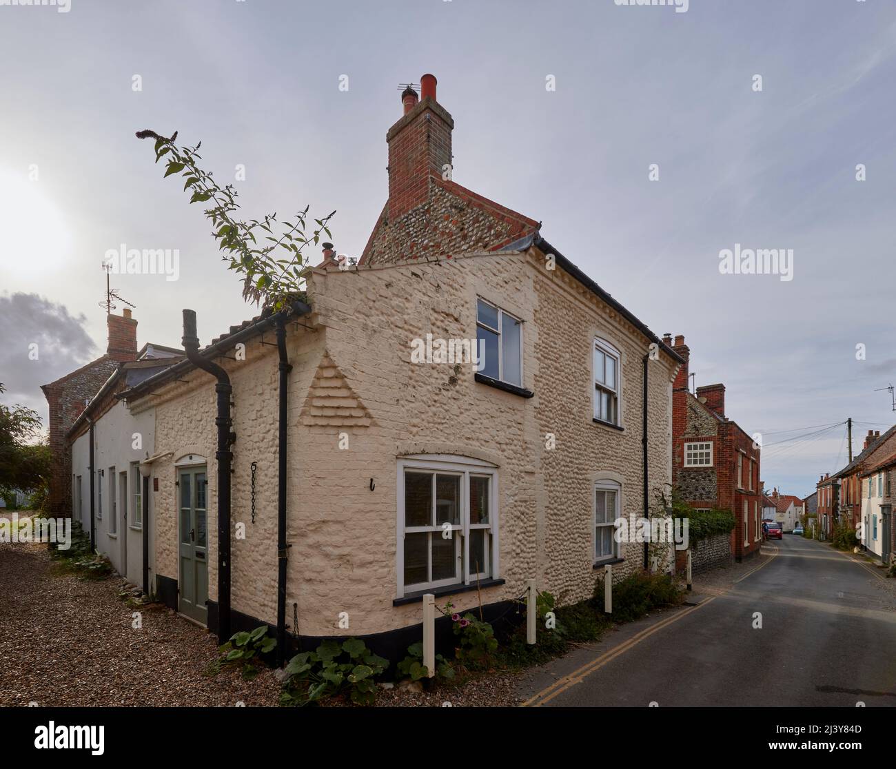 Street scene with local style roadside flint stone walls Blakeney, a