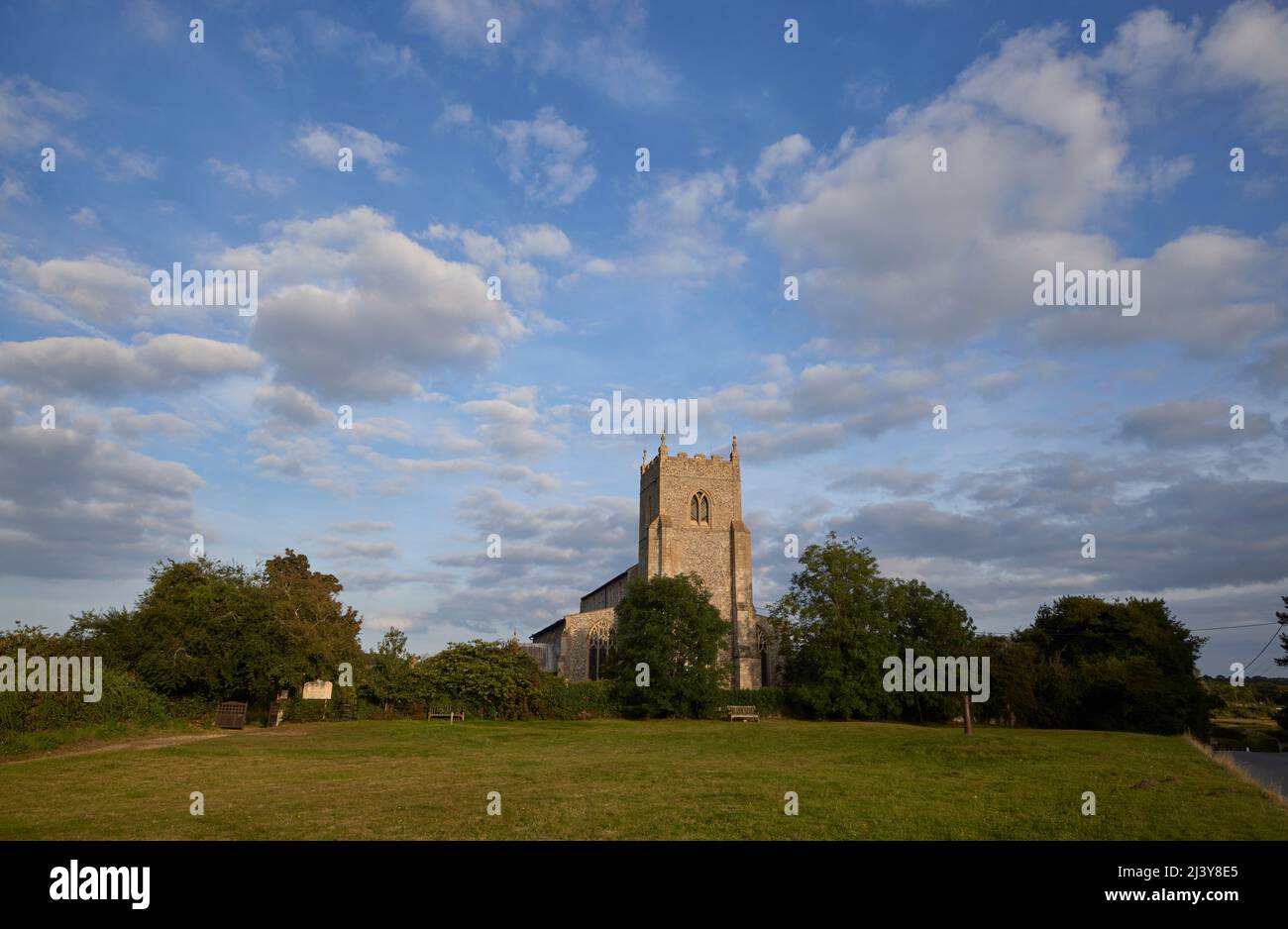 St Mary the Virgin Church with blue sky and fluffy white clouds, Wiveton, a small village in north Norfolk, East Anglia, England Stock Photo