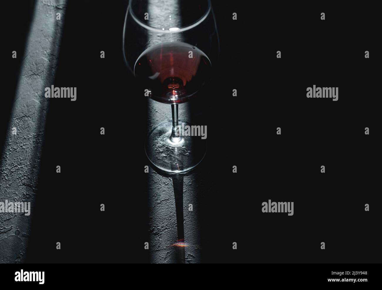 https://c8.alamy.com/comp/2J3Y948/wine-glass-with-traditional-round-goblet-shape-filled-with-dark-red-wine-and-slim-stem-on-table-selective-focus-2J3Y948.jpg