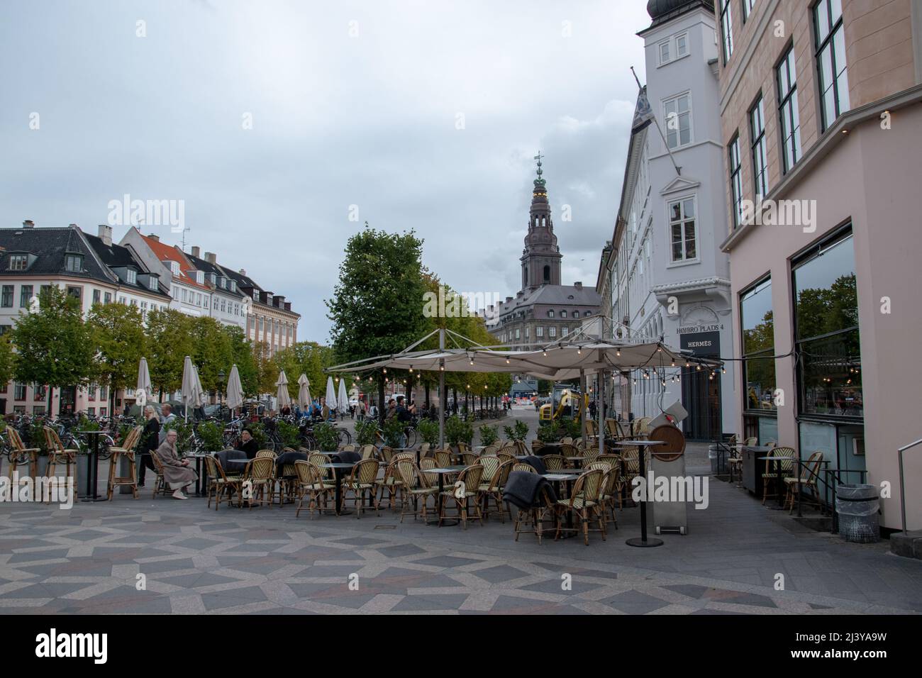 Patrons sit at tables and chairs outside of Cafe Europa in the city centre, Copenhagen, Denmark, September 23, 2018. Stock Photo