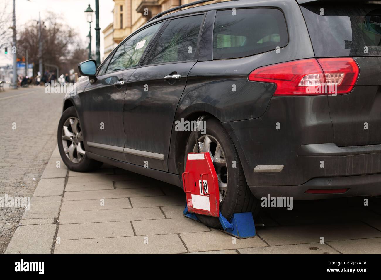 Car wheel clamp Locked illegally parked cars Car wheel blocked by wheel lock because of illegal