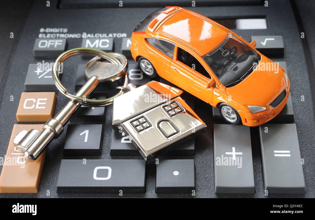 HOUSE KEY RING AND KEY WITH MODEL CAR ON CALCULATOR RE COST OF LIVING RISING BILLS MOTORING MORTGAGES INCOME WAGES ETC UK Stock Photo