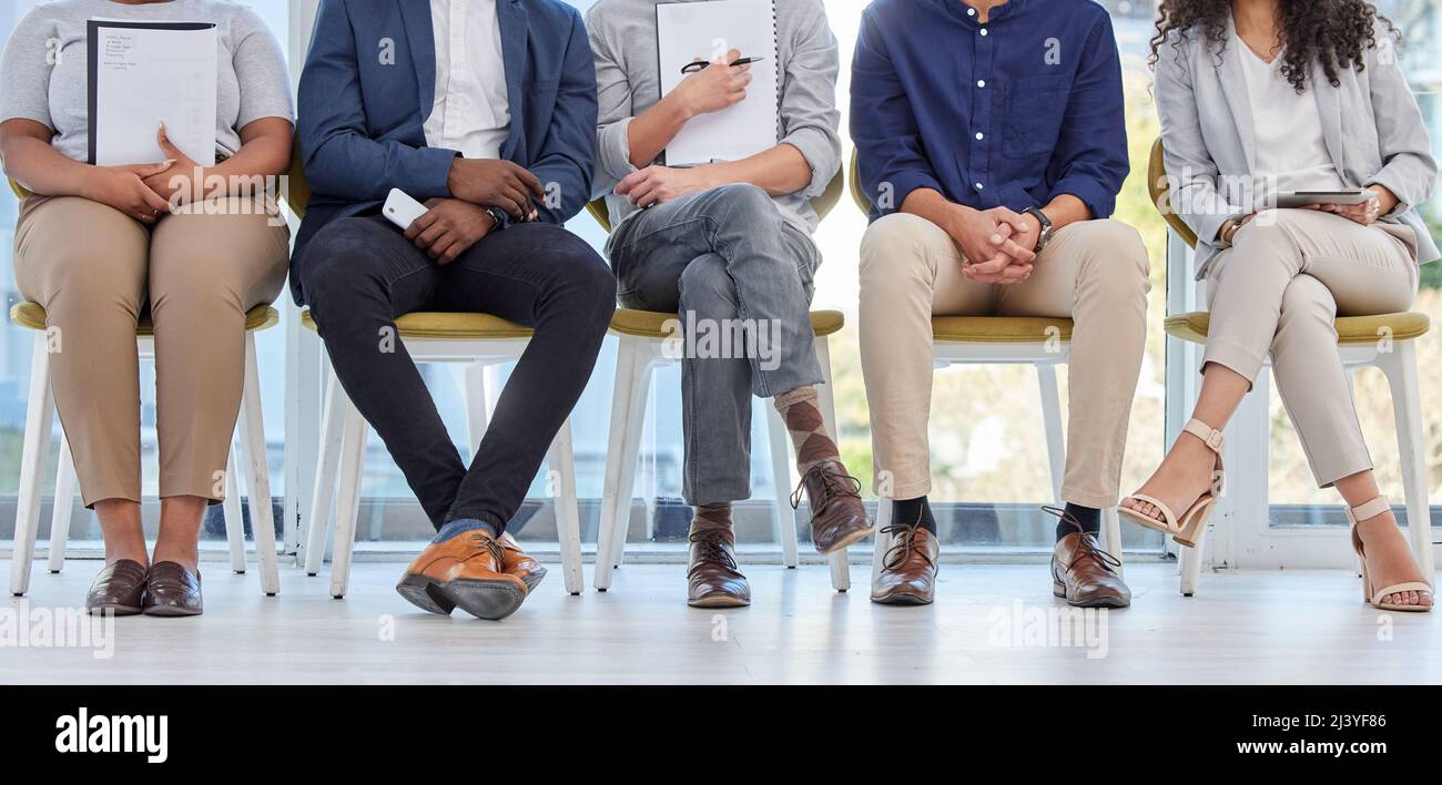 Please wait your turn. Closeup shot of a group of businesspeople sitting in line in an office. Stock Photo