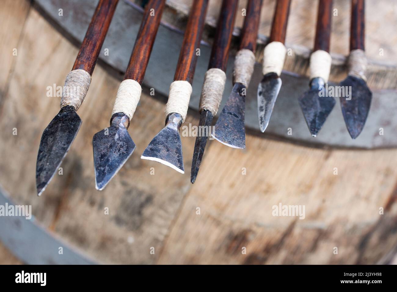 Different types of arrowheads made of iron on wooden background Stock