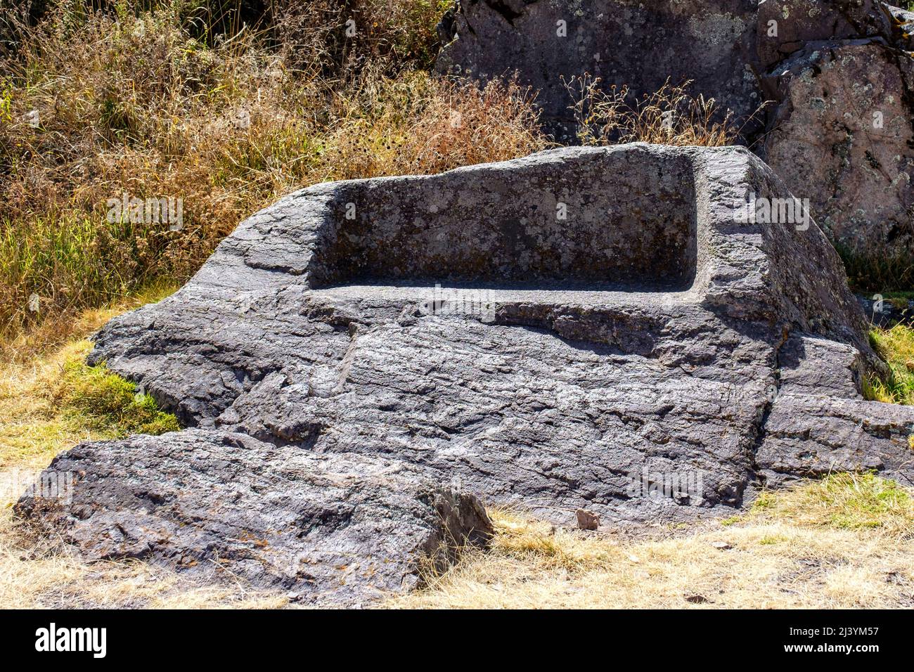 Stone bench at Intihuatana sector of Pisac Inca fortress ruins, Peru Sacred Valley. Stock Photo