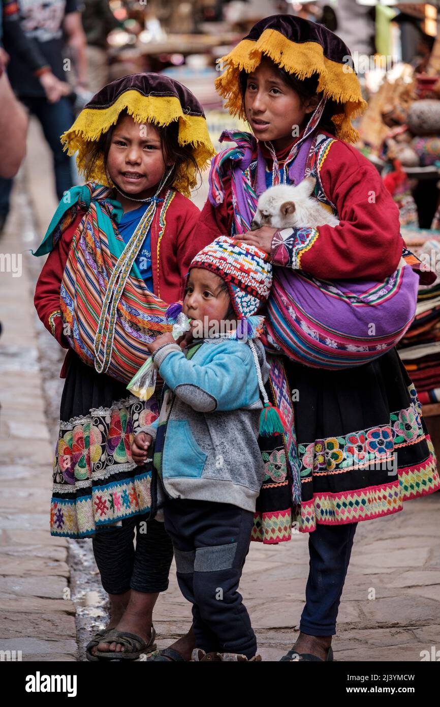 Quechua children dressed in traditional clothing at Pisac Sunday Market, Peru Sacred Valley Stock Photo