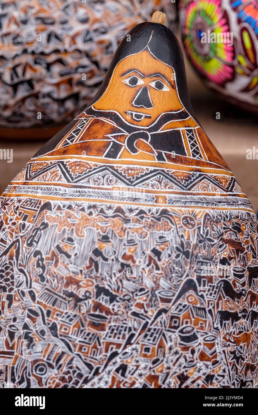 Mate burilado, carved gourd depicting the Andean deity Pachamama for sale at Pisac Sunday Market, Peru Stock Photo