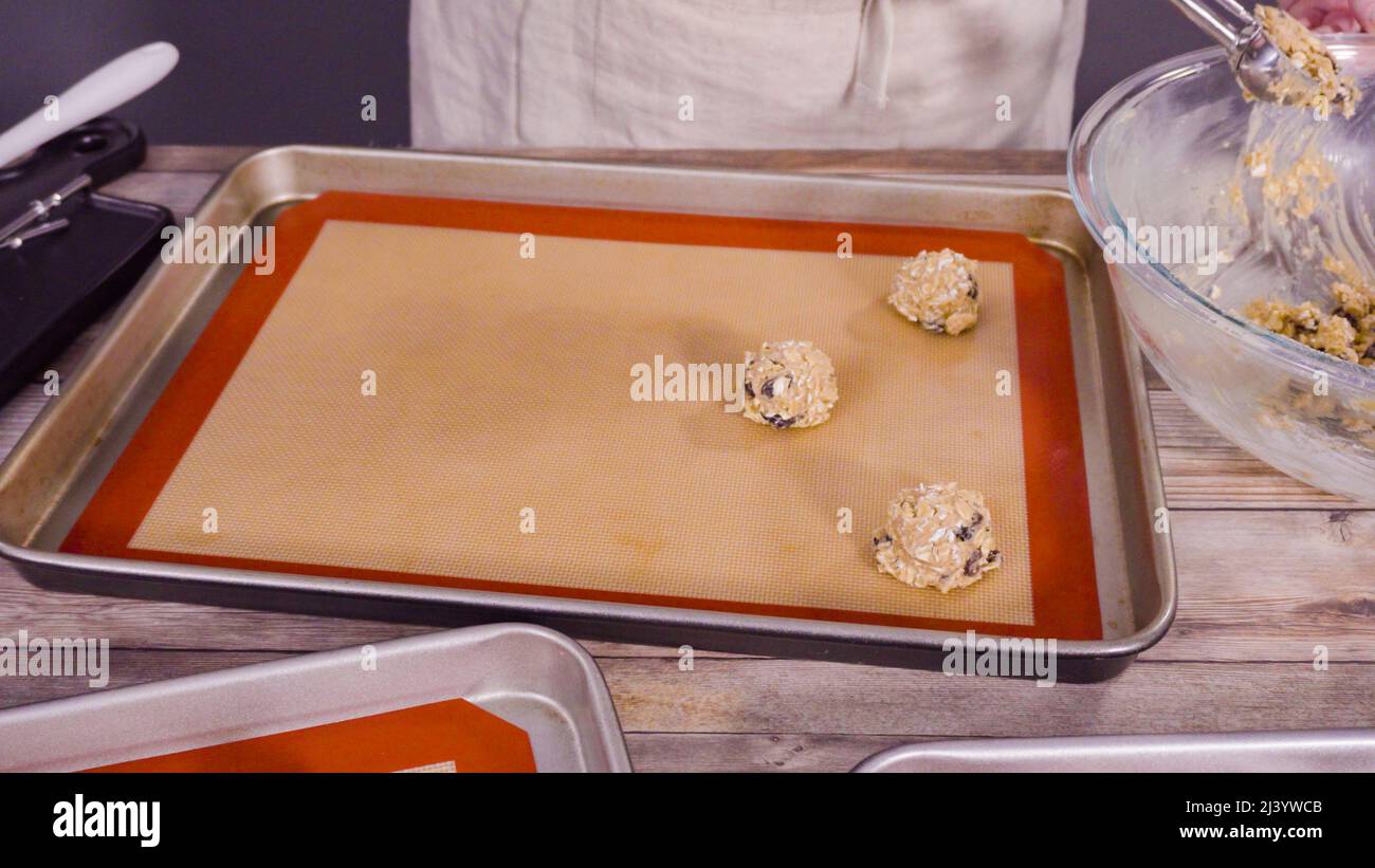 Step by step. Scooping cookie dough with a dough scoop into the baking sheet Stock Photo Alamy