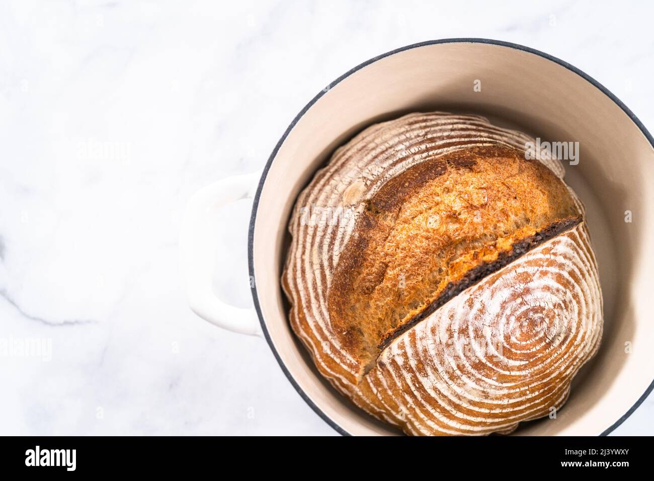 Freshly baked loaf of a wheat sourdough bread with marks from bread