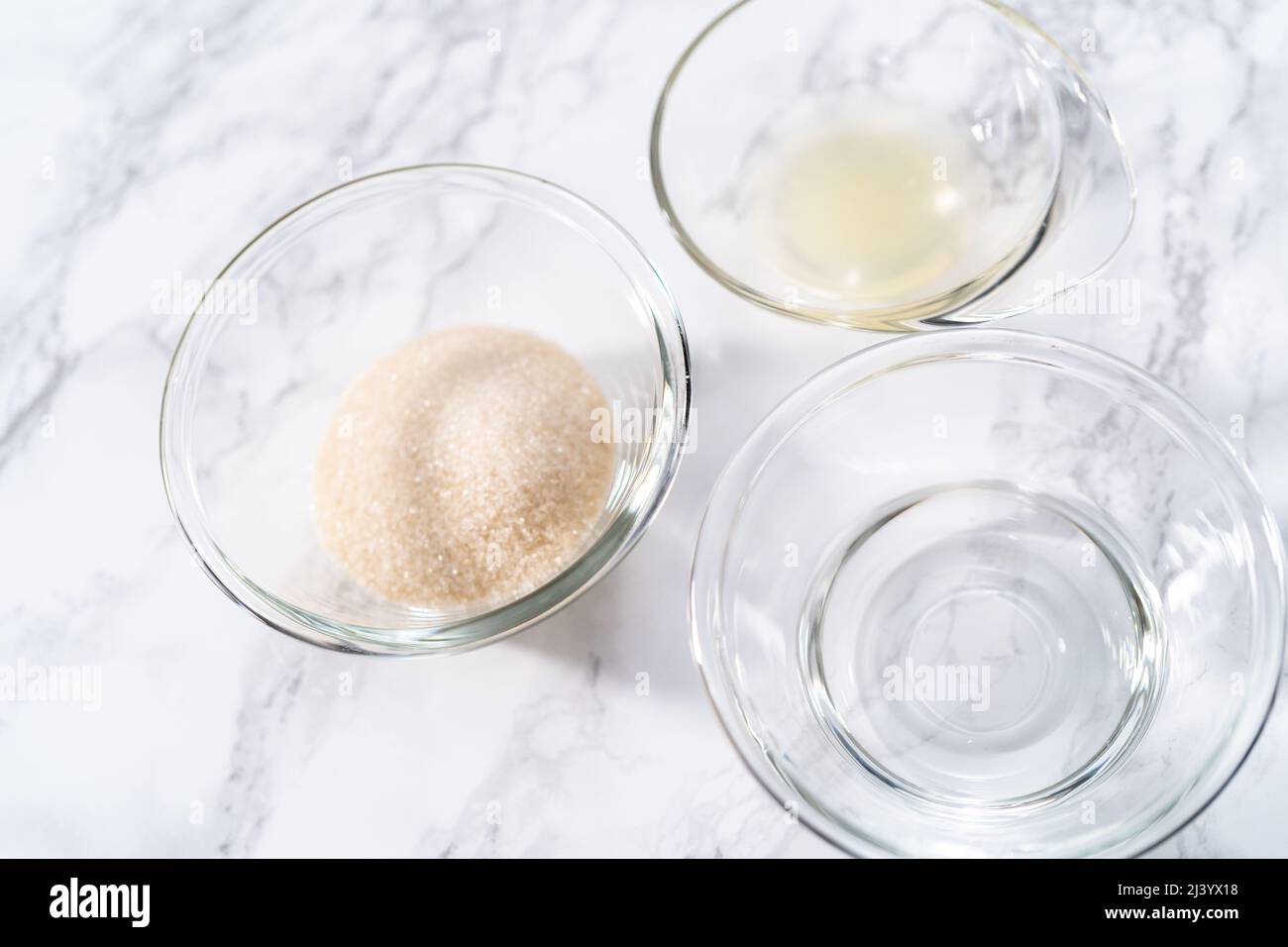 Ingredients in a glass mixing bowls to bake a lemon pound cake Stock