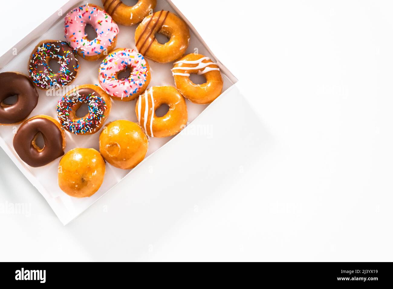 Flat lay. Variety of storebought doughnuts in a white paper box Stock