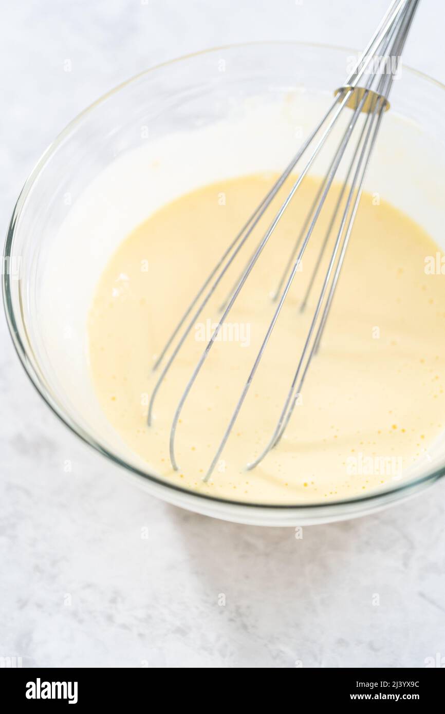 Mixing ingredients in a glass mixing bowl to bake July 4th bundt cake