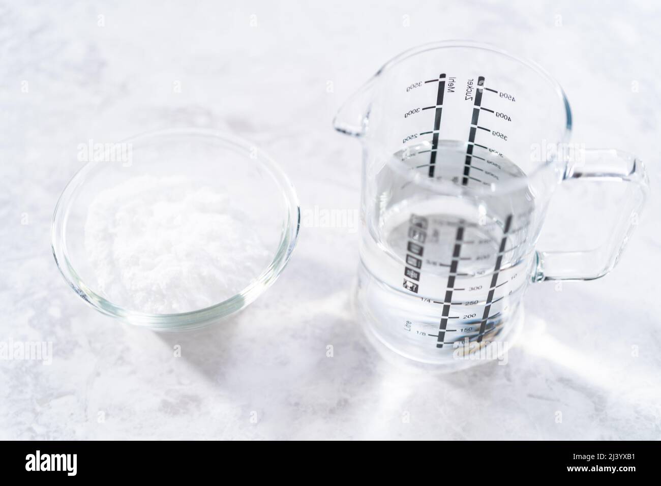 Baking soda and vinegar in glass containers for cleaning cast iron