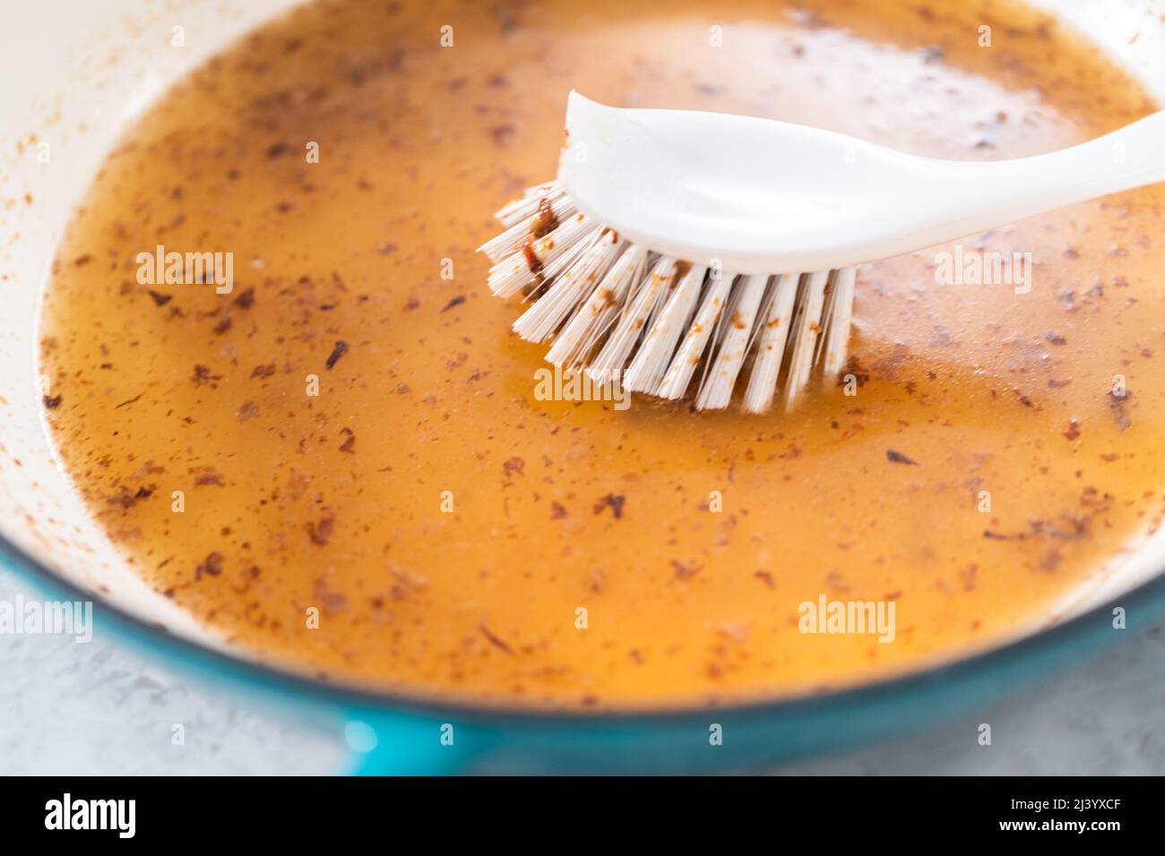 Cleaning cast iron enameled braiser with baking soda and vinegar Stock