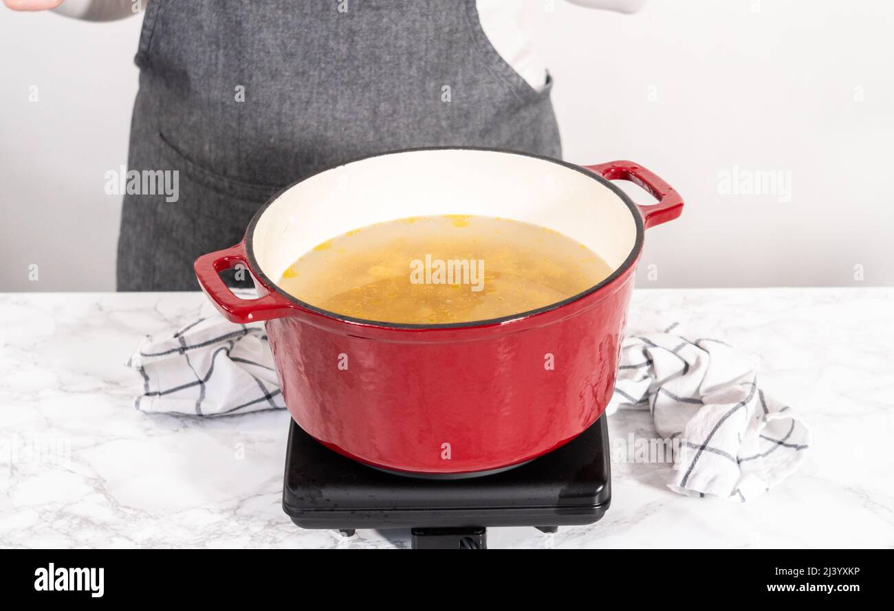 Boiling pasta in an enameled dutch oven to prepare chicken alfredo